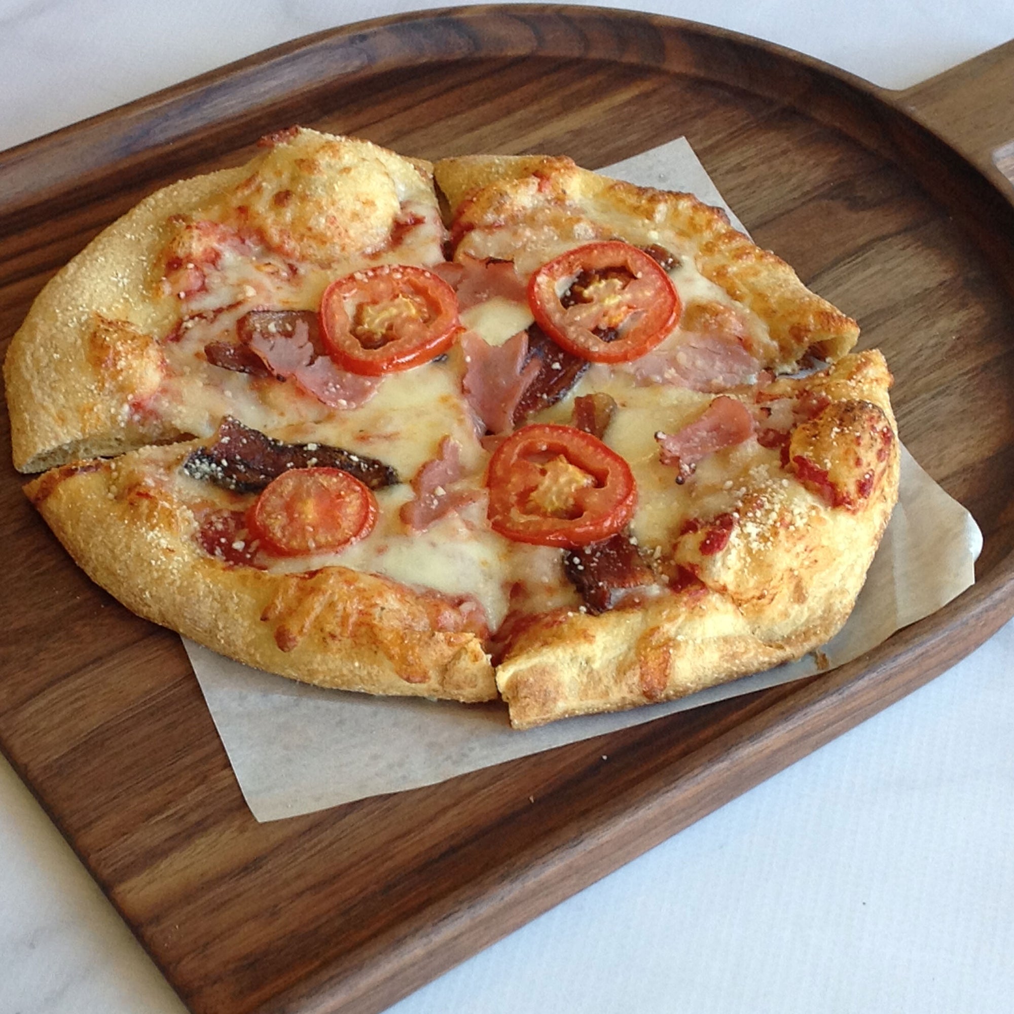Small pizza on a walnut charcuterie food presentation board by Michael's Woodcrafts Greenville SC woodworkers woodworking artist