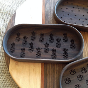 Walnut catchall tray with pineapples engraved on the bottom of the tray
