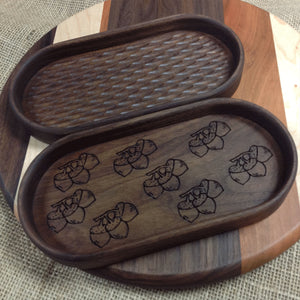 Two walnut catchall trays one has a bunch of acorns engraved on the bottom, the other has carved bottom