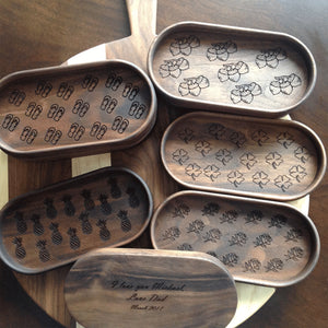 five walnut catchall trays with different engravings on the bottom of tray, pineapples, acorns, four leaf clovers and roses  by Michael's Woodcrafts Greenville SC woodworker Woodworking artist woodworkers
